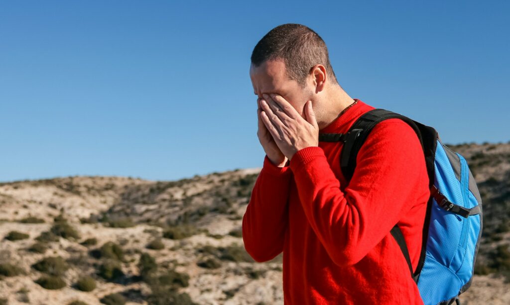 A man wearing a red crew-neck sweater