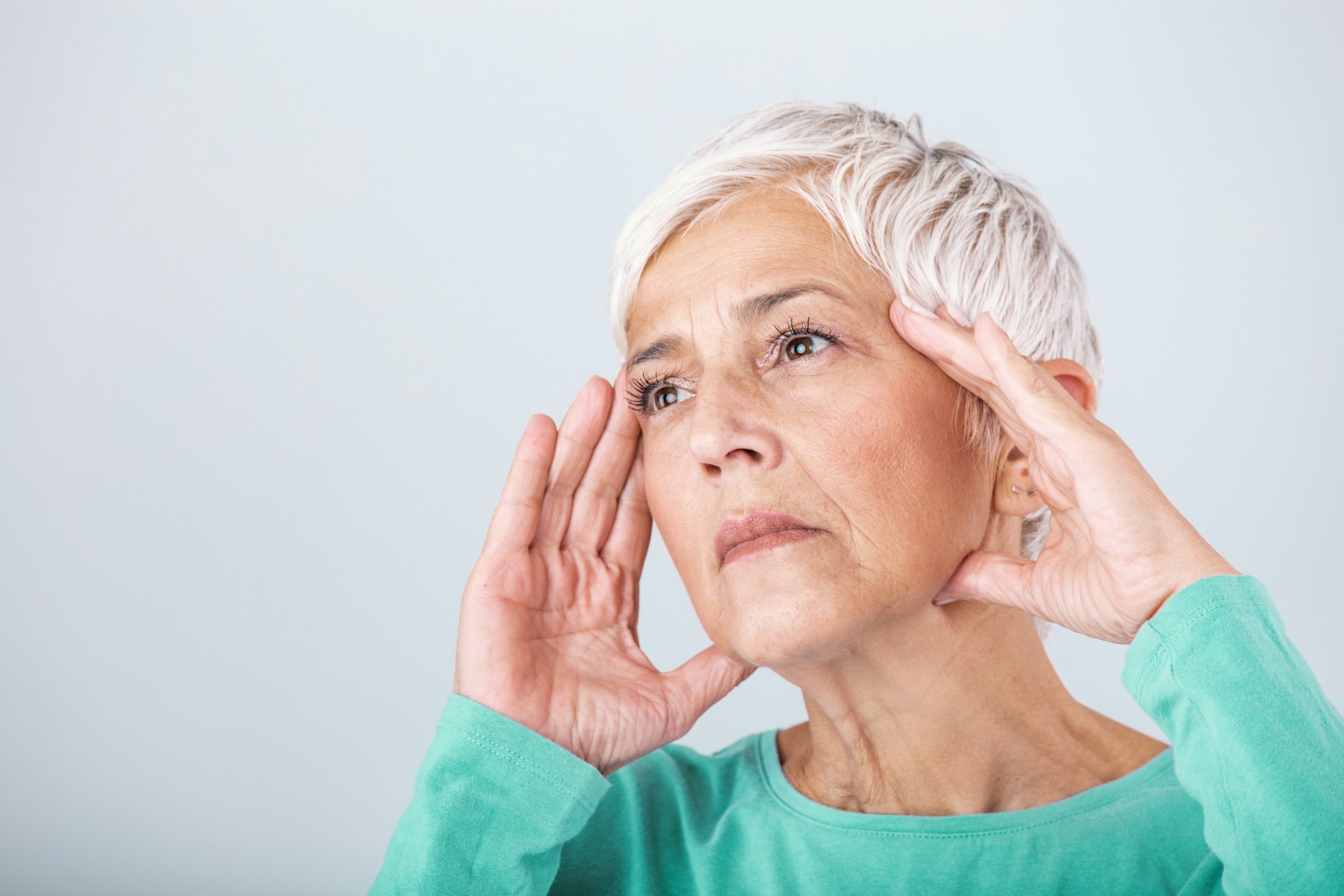 An old woman holding her head