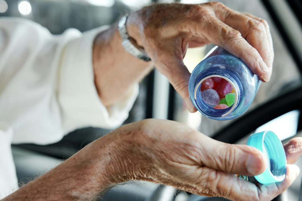 Old person holding a plastic cup