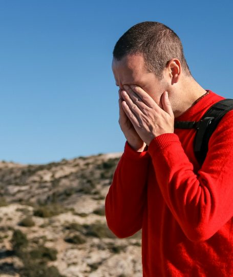 A man wearing a red crew-neck sweater