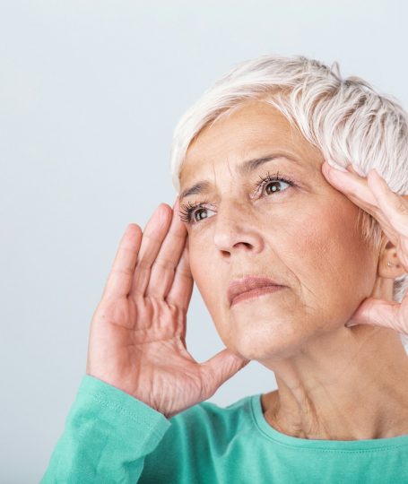 An old woman holding her head