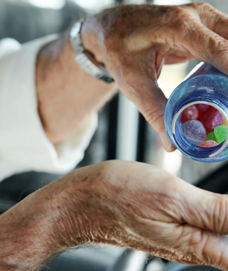 Old person holding a plastic cup